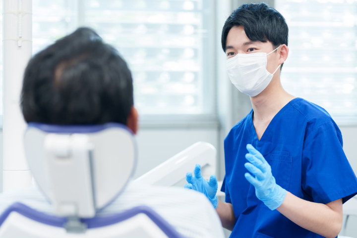 歯周病の進行を止めるために定期的に歯科検診を受ける男性と歯科医師