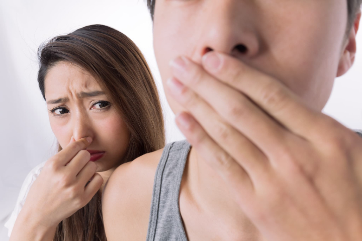 口臭を気にする男性と鼻をつまむ女性